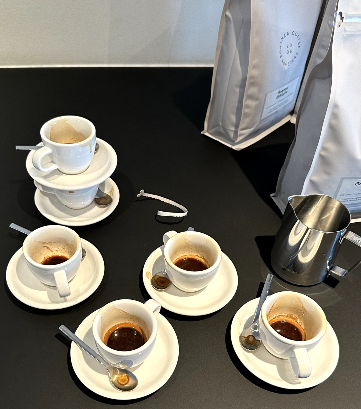 Multiple espresso cups stacked above each other with leftovers of coffee