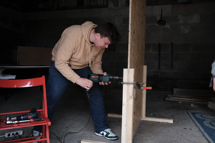A member of the proiject team builidng one of the wooden walls