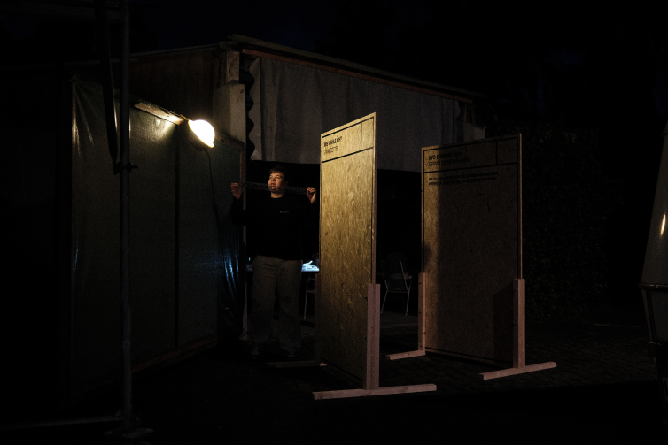 A member of the project team sticking the print onto the wooden walls