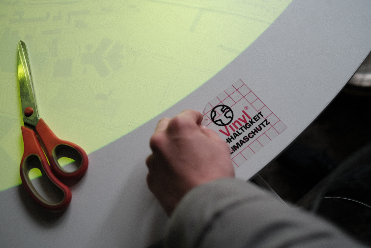 A member of the project team placing a sticker with cutout text onto the game table