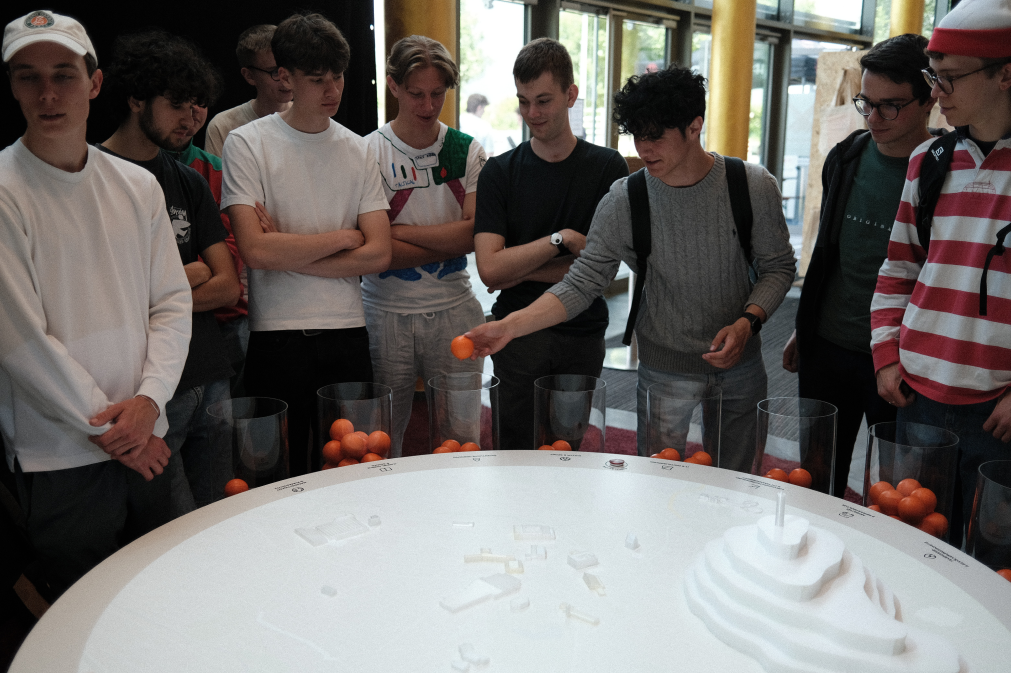 Participants dropping orange balls into transparent tubes