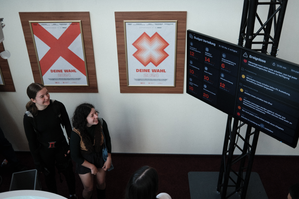 Participants looking at a screen showing a list with events triggered by the distribution of the money